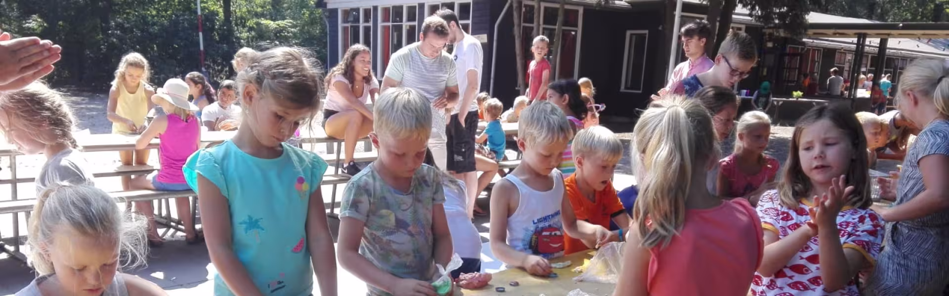 Kinderen knutselen aan lange tafels