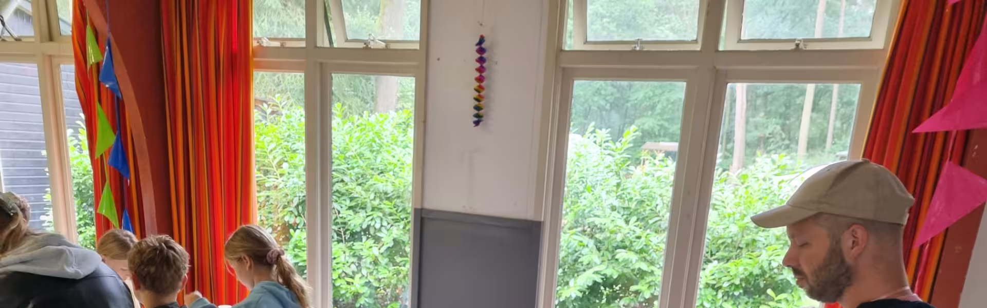Kinderen knutselen aan tafel in de zaal