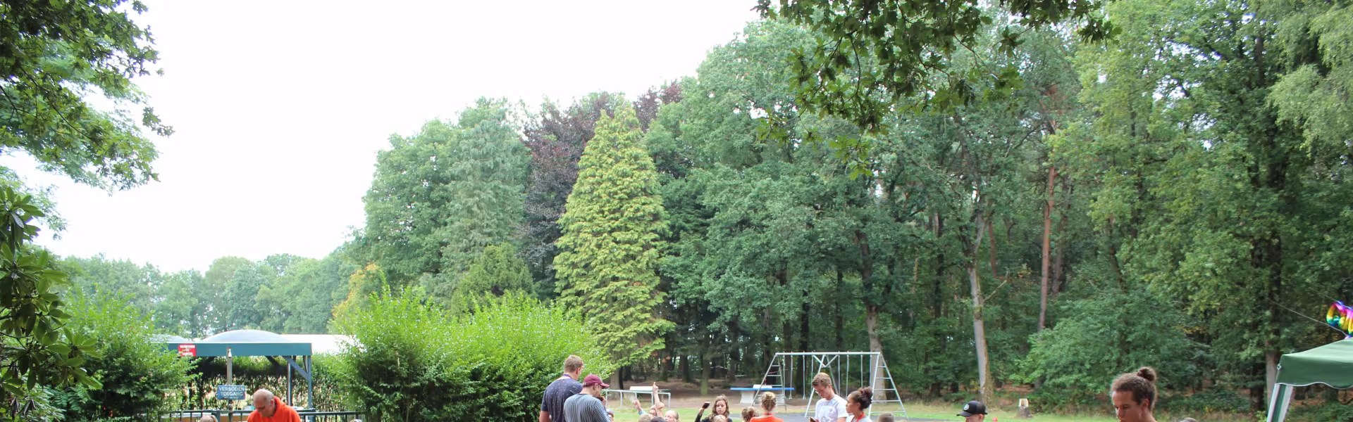 Deelnemers aan lange tafels onder de overkapping