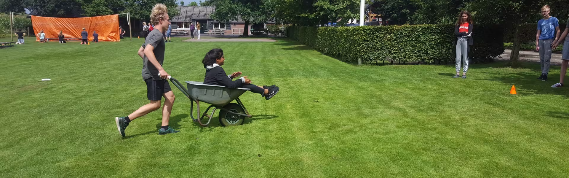 Deelnemer rijdt met een bolderkar over het grasveld