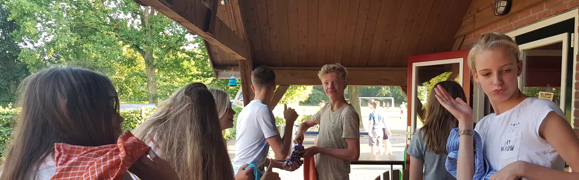 Deelnemers aan tafel onder een overkapping