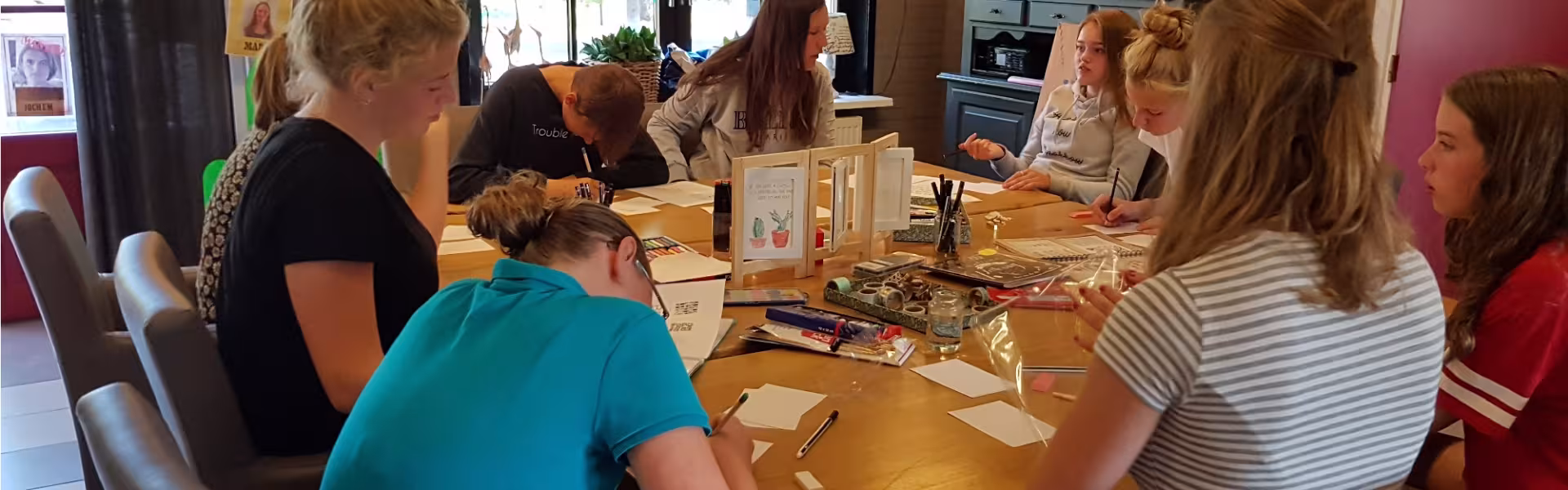 Deelnemers aan tafel in het kampgebouw