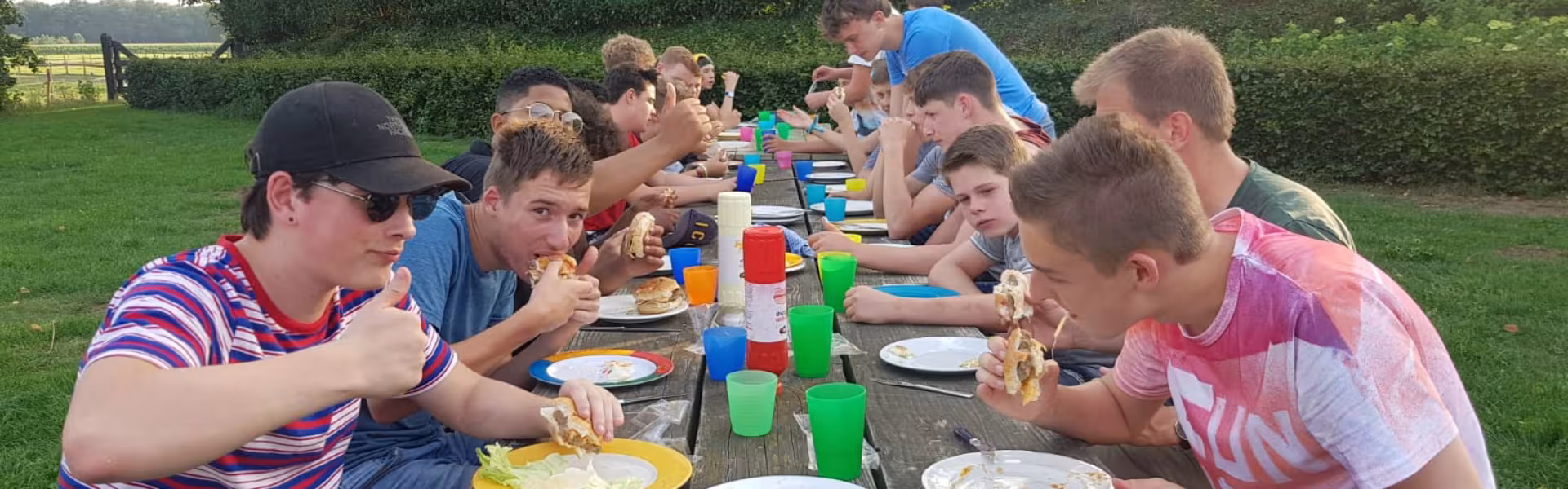 Deelnemers eten samen aan een lange tafel