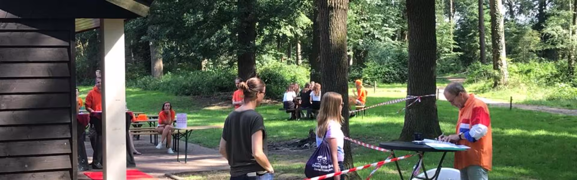 Deelnemers bij het kampgebouw met een rode loper