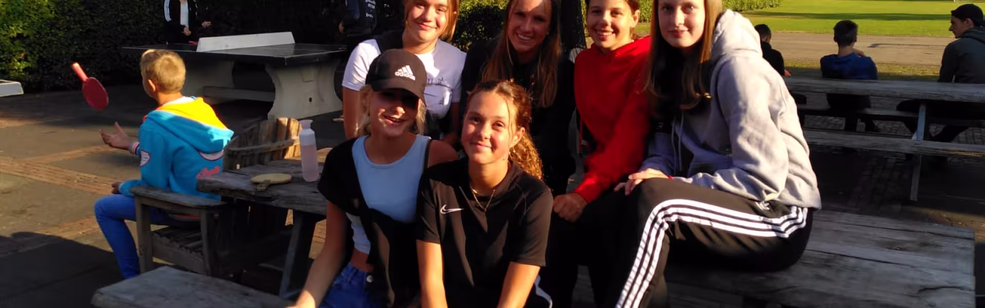 Deelnemers zitten op een picknicktafel