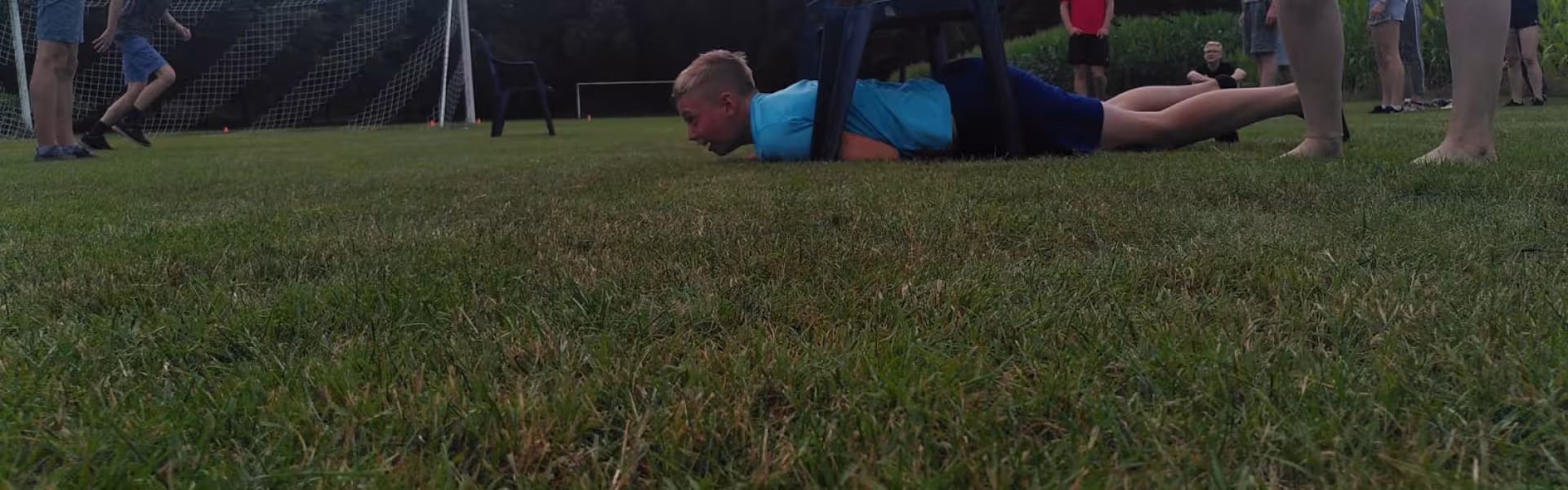 Deelnemers liggen op het grasveld tijdens een spel