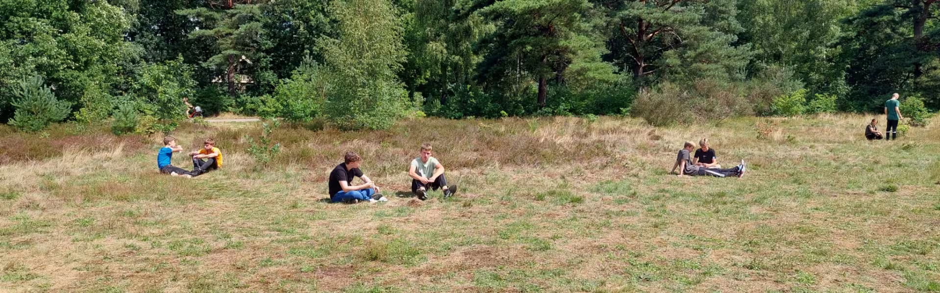 Deelnemers zitten verspreid op de heide