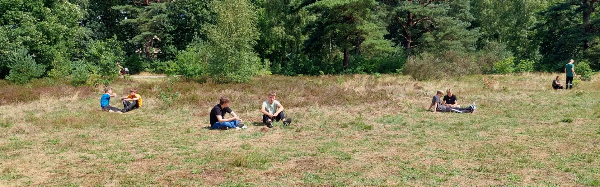 Deelnemers zitten verspreid op de heide