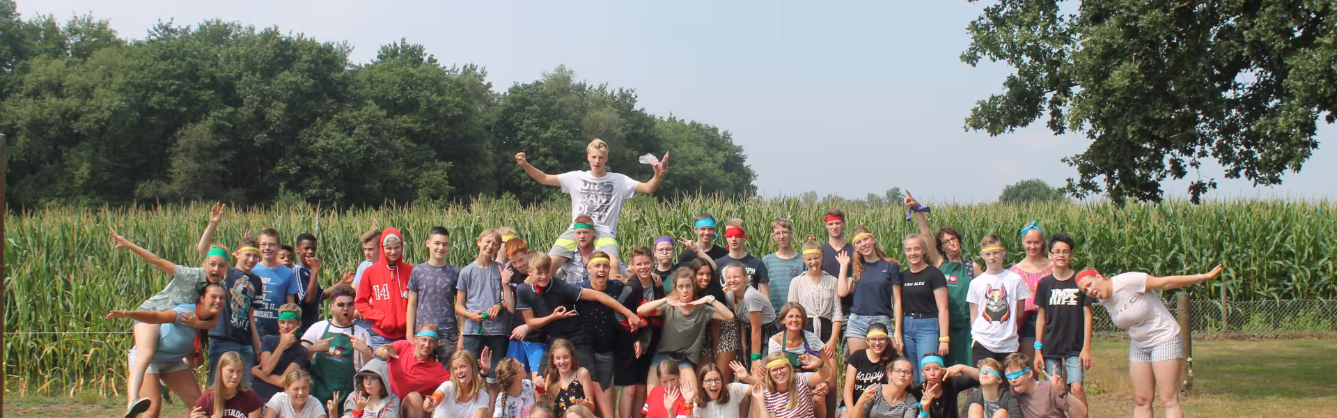 Grote groepsfoto van deelnemers voor een maisveld