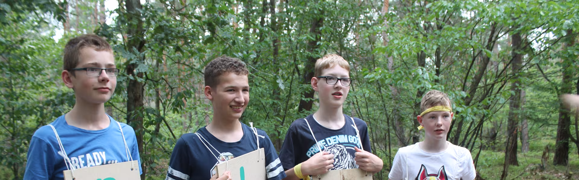 Deelnemers houden borden omhoog met de letters P L A S