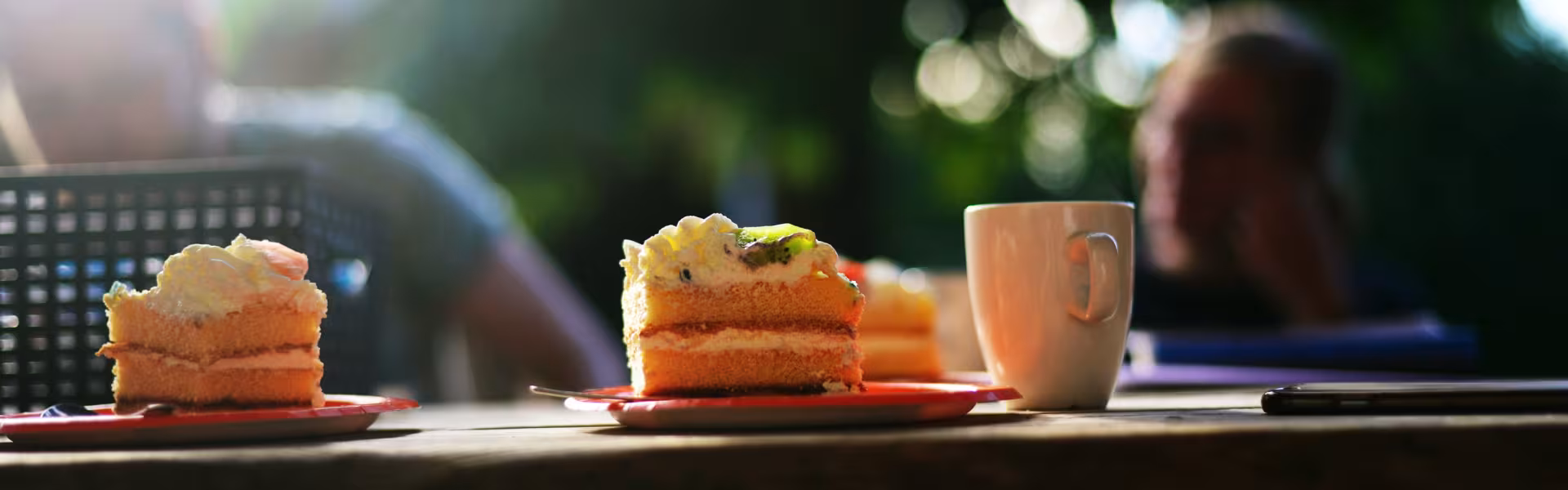 Cake en een beker op een houten tafel buiten