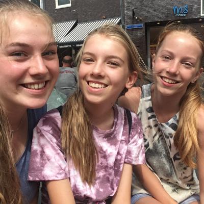 Drie meisjes lachen naar de camera