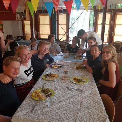 Deelnemers aan een gedekte tafel met vlaggetjes