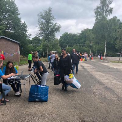 Deelnemers met bagage op het terrein bij aankomst