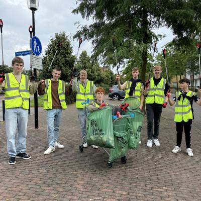 Deelnemers in veiligheidshesjes op een bospad