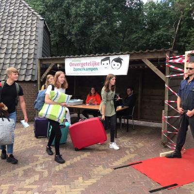 Deelnemers met bagage op een rode loper