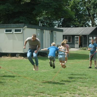 Kinderen rennen over het grasveld bij de tent