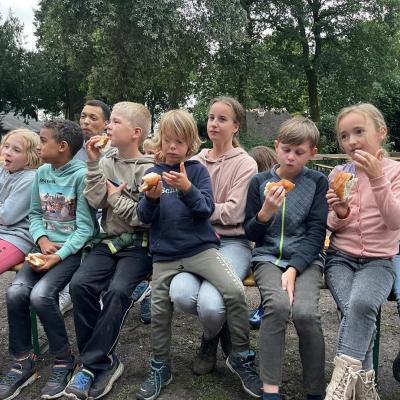 Deelnemers zitten op een rij te eten