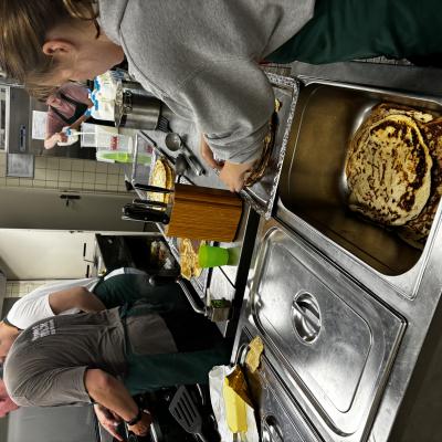Keukenmedewerker haalt een schaal uit de oven