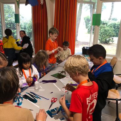 Kinderen knutselen aan tafel in de zaal