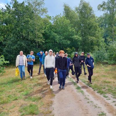 Deelnemers lopen over een bospad
