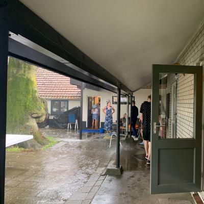 Overdekt terras bij het kampgebouw in de regen
