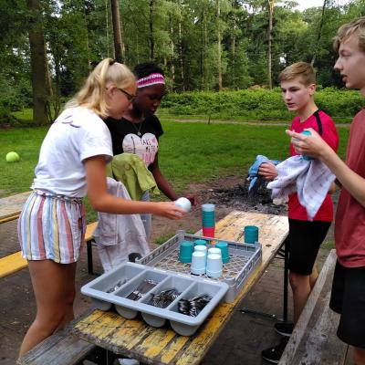 Deelnemers spelen een spel met bekers op tafel
