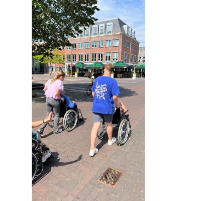 Deelnemers lopen door een straat in het dorp