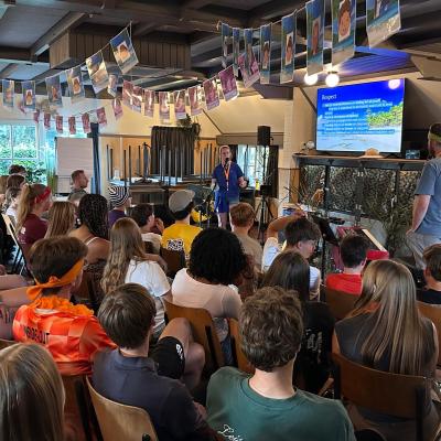 Deelnemers kijken naar het scherm in de zaal