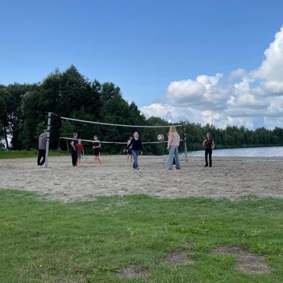 Deelnemers spelen volleybal op het zandveld