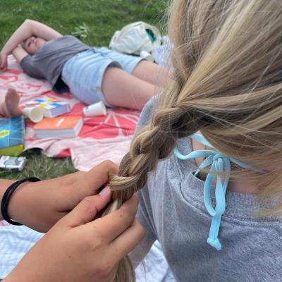 Deelnemer met een gevlochten haar in het gras
