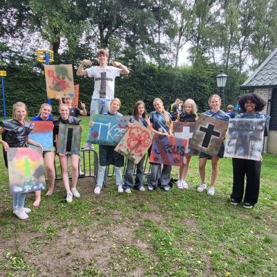 Deelnemers poseren op het grasveld